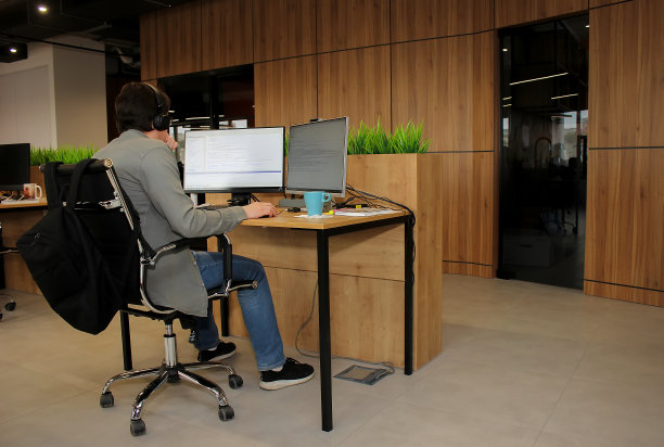 一名年轻的员工在办公室工作时看着电脑显示器图片下载