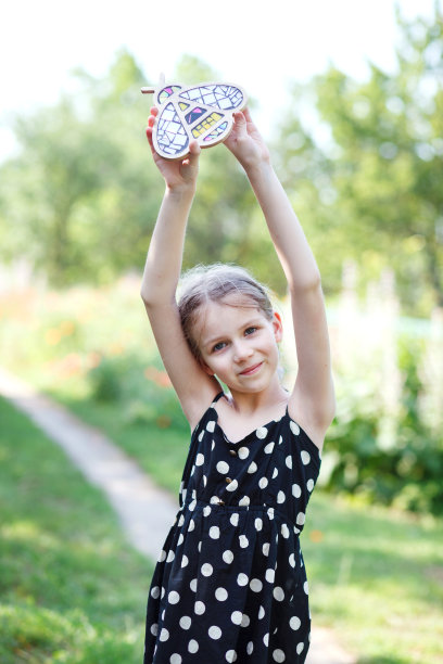 一个女孩抱着一只蜜蜂，在野花的背景上有马赛克图案。图片下载