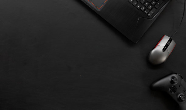 俯视图的玩家办公桌工作空间与咖啡杯和笔记本电脑在黑色的桌子背景。平躺图片下载