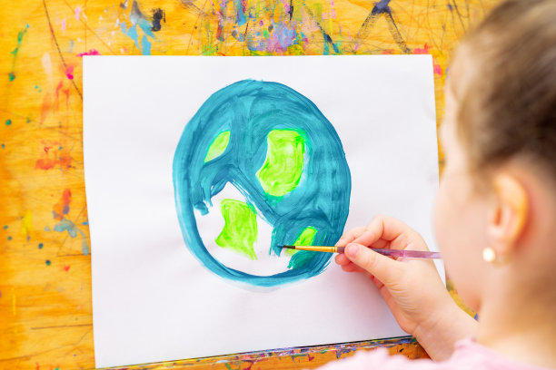 小女孩正在画地球。图片下载