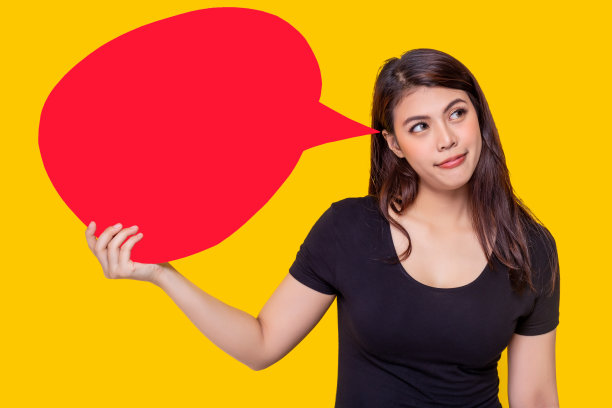 亚洲妇女举行泡沫演讲。漂亮的亚洲女孩思考购物，表现得像一个决定，她应该买她最喜欢的东西。迷人美丽的年轻女性肖像。黄色背景图片下载