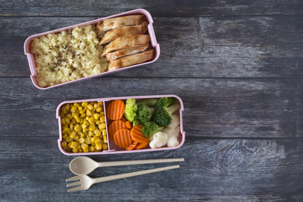 午餐盒与新鲜的膳食在一个深色的木材背景。西兰花，玉米，卷心菜，胡萝卜，鸡肉。健康饮食的工作理念图片下载