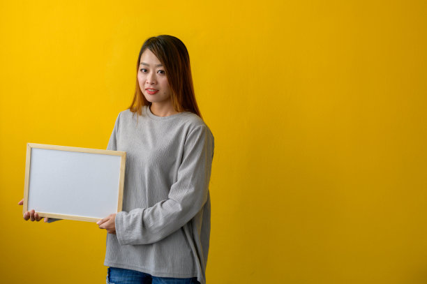 女人拿着黄色背景的白板图片下载