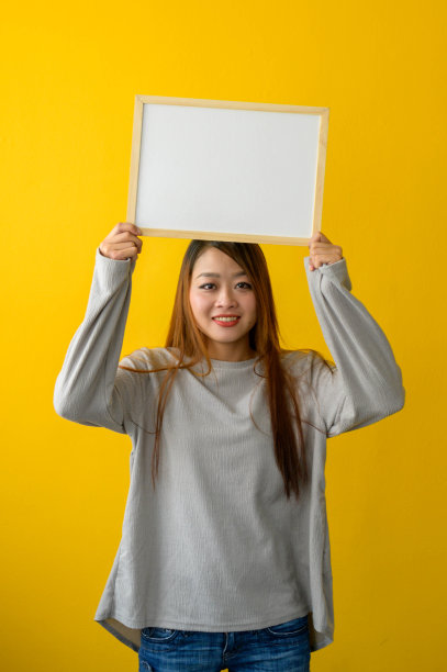 女人拿着黄色背景的白板图片下载