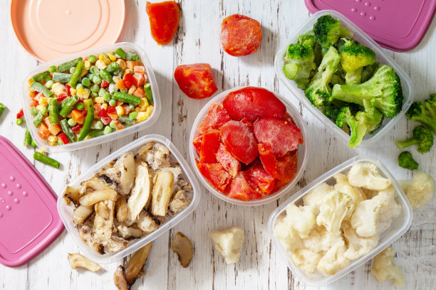 冷冻蔬菜。储存过冬的食物。装冷冻蔬菜和蘑菇的容器。俯视图平铺背景图片下载