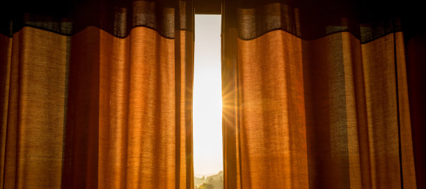 日出的阳光透过敞开的窗帘缝隙，使房间赏心悦目图片下载