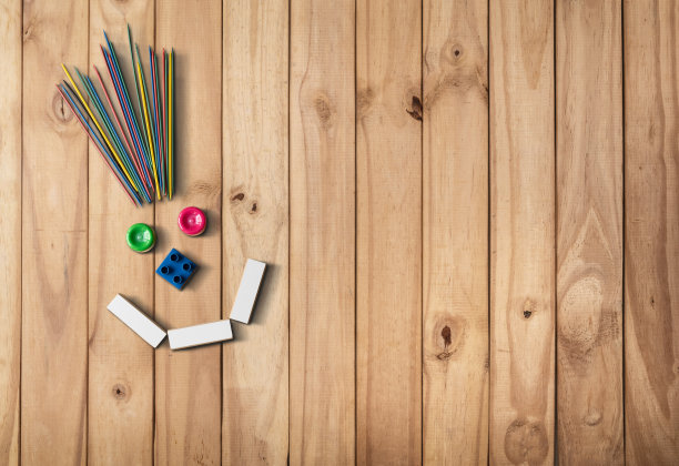 在木地板上用儿童材料制作的笑脸。图片下载