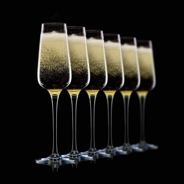 一组豪华香槟酒杯在一排孤立的黑色背景图片下载