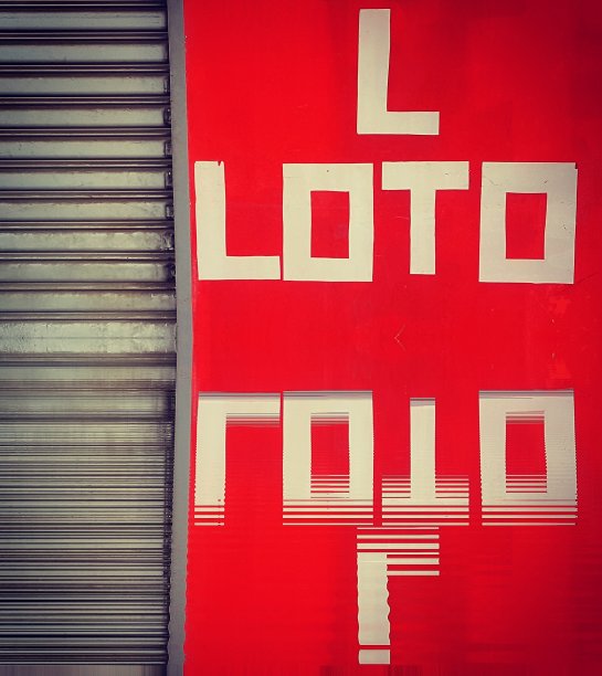 L LOTO标识的水反射在生动的红色墙壁和灰色钢百叶窗上图片下载