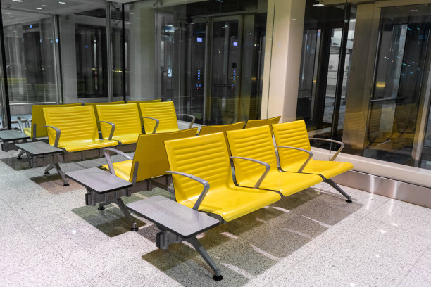 机场候机区的一排排黄色长凳。图片下载