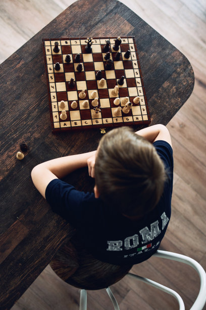 一个男孩在隔离期间在家下棋。休闲爱好。图片下载