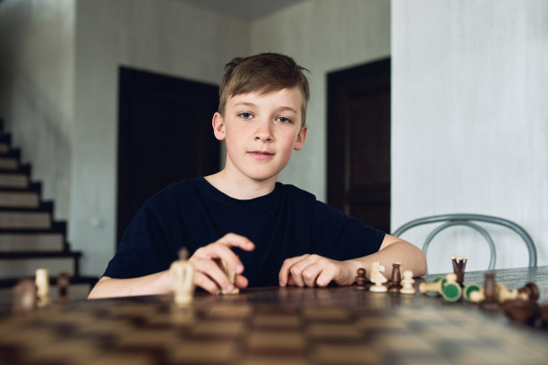 一个男孩在隔离期间在家下棋。休闲爱好。图片下载