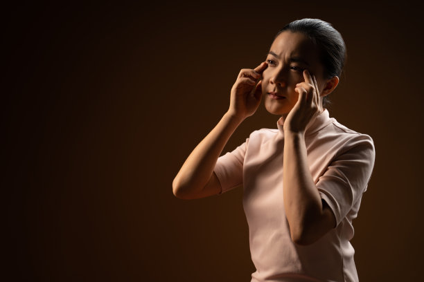 一名亚洲妇女生病，眼睛疼痛，孤立地站在米色背景。图片下载