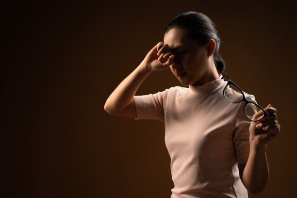 一名亚洲妇女生病，眼睛疼痛，孤立地站在米色背景。图片下载