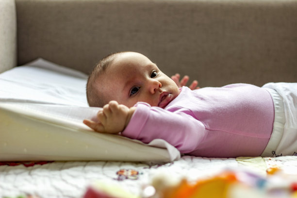 近距离图片可爱，快乐和胖乎乎的婴儿女孩在粉红色的紧身衣。图片下载