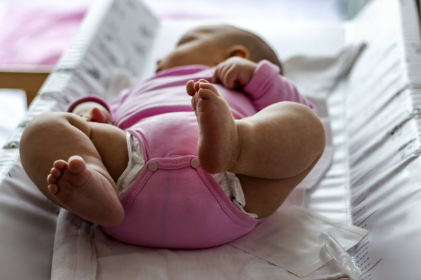 初生女婴的脚躺在婴儿床上的照片。图片下载