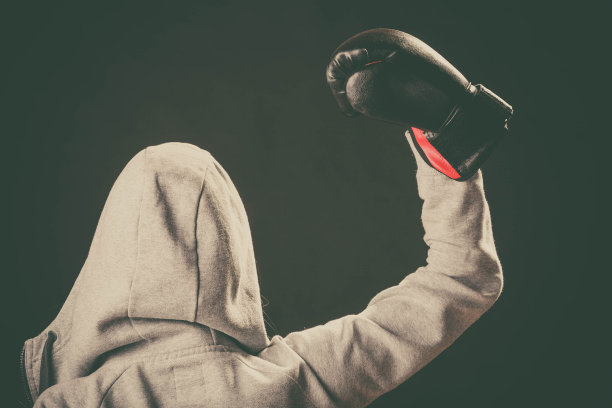 穿着帽衫的拳击手向后站，手举在空中。图片下载