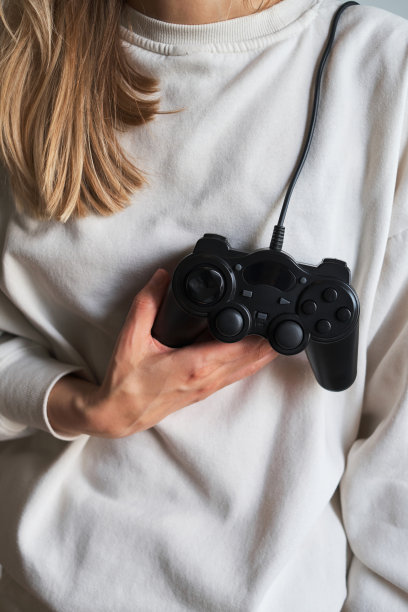 手柄在一个女孩手里。玩家与操纵杆。玩家玩电脑和主机游戏。Сontroller电子竞技和网络体育。游戏成瘾，游戏生活理念。爱好和休闲图片下载