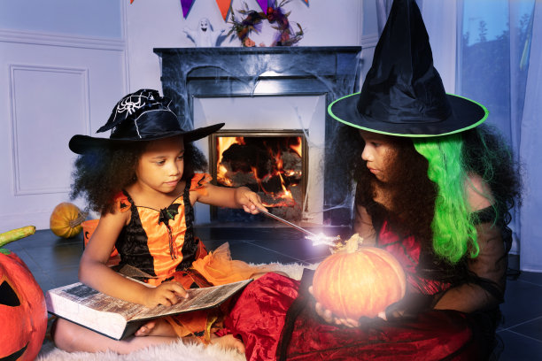 可爱的女孩在万圣节南瓜上施魔法图片下载