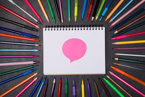 论坛在学校手工手工概念。上面的头顶上的彩色钢笔和铅笔的照片周围的空白笔记本与粉红色泡沫贴纸隔离在黑板上图片下载