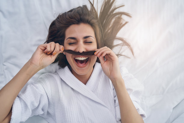 快乐的年轻女人在卧室在家里玩图片下载