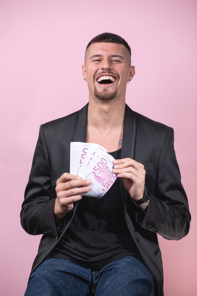 快乐的彩票中奖者拿着他的一大笔钱图片下载