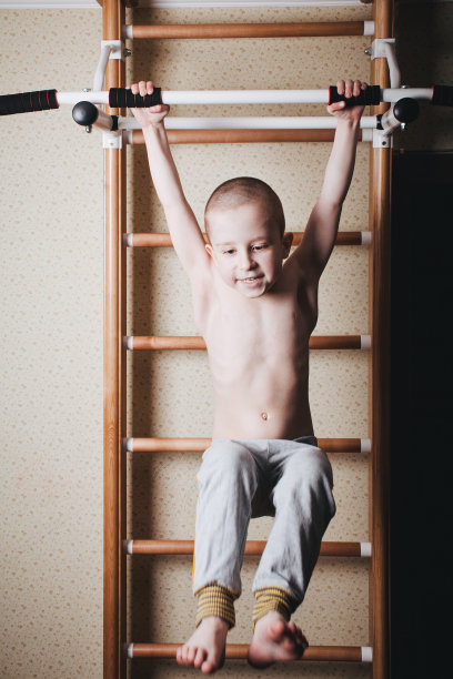 在家锻炼。男孩在吊架上抬起了腿图片下载