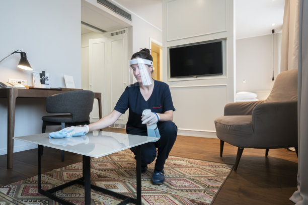 服务员在酒店打扫房间，在酒店工作时戴着口罩图片下载