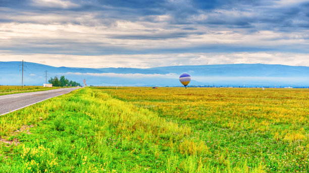夏天的风景如画，山谷，绿草如茵，多云的天空，在飞行前还有公路和热气球。有雾的早晨，通金斯基区，布里亚特，俄罗斯图片下载