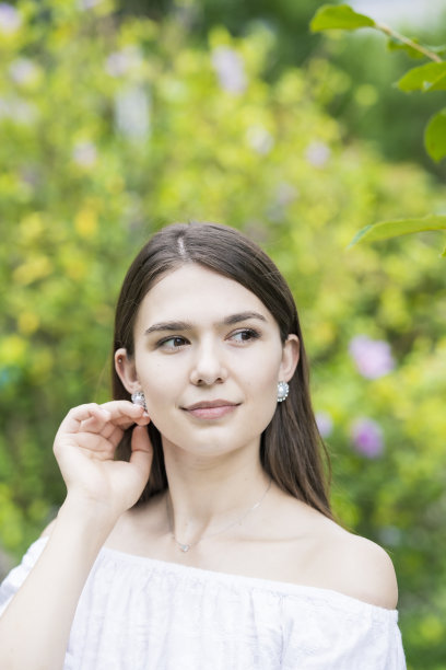 一个穿着白色露肩衬衫的年轻女子图片下载