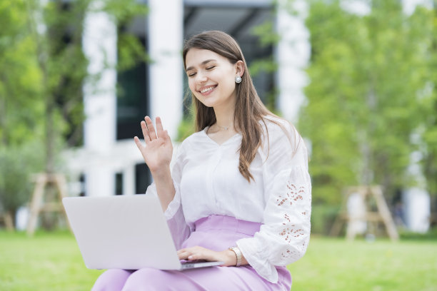 年轻女子向笔记本电脑屏幕致意图片下载