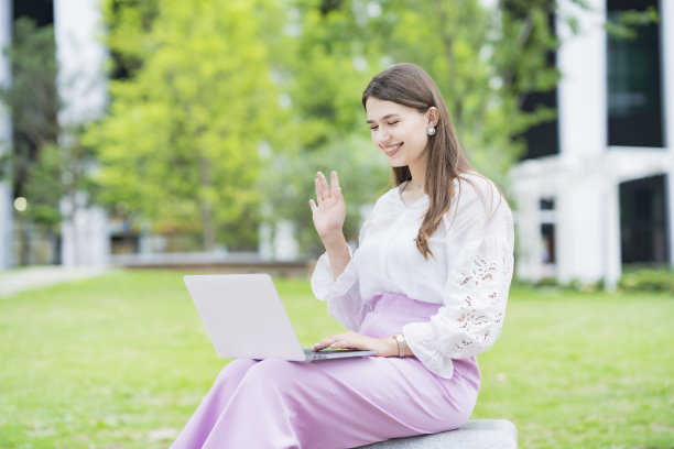 年轻女子向笔记本电脑屏幕致意图片下载