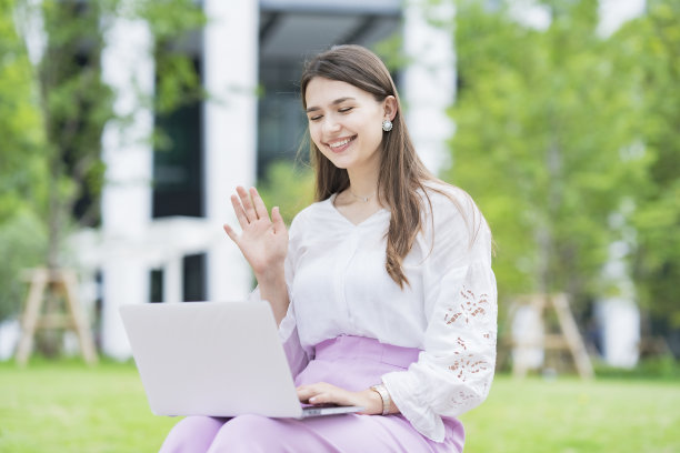 年轻女子向笔记本电脑屏幕致意图片下载