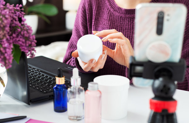 脸、手、身体护理霜。霜在美容博主女性的手中。网红进行在线视频内容录制，对化妆品进行直播评论。美容培训，皮肤护理教程。图片下载