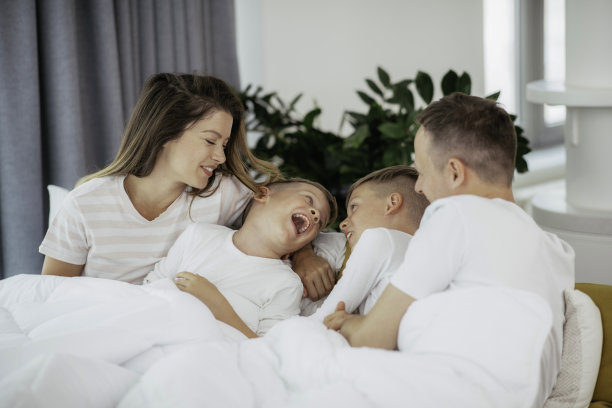 快乐的父母，儿子在床上休息。图片下载