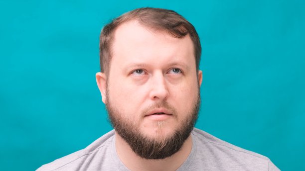 在绿色背景下，一名蓄着胡须的男子惊恐地看着图片下载