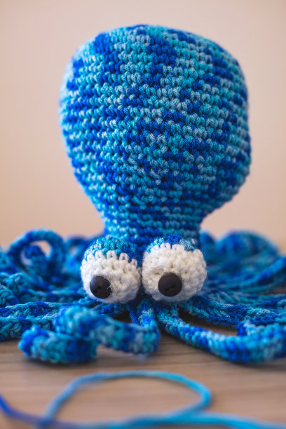 可爱的毛线娃娃躺在桌子上图片下载