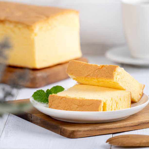 简单经典的台湾传统海绵蛋糕(台湾castella kasutera)放在一个木制托盘背景桌子上，与原料，近距离。图片下载