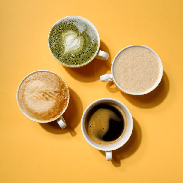 顶视图创意美式卡布奇诺拿铁艺术咖啡和热抹茶，如此美味的硬光在彩色的黄色背景。咖啡杯系列与硬阴影图片下载