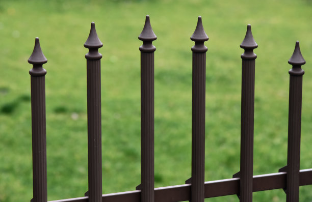 传统边界墙的金属物体，以绿色为背景图片下载