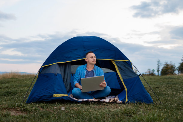 一名男性自由职业者正在山里的户外笔记本电脑上工作。自由的概念。图片下载