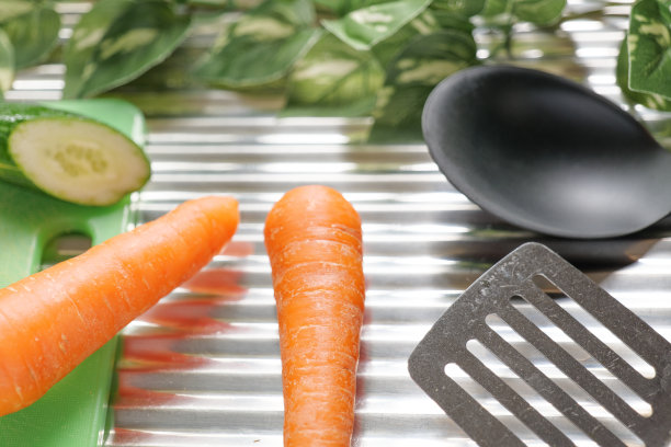 不锈钢背景上的炊具和蔬菜图片下载