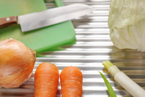 不锈钢背景上的炊具和蔬菜图片下载