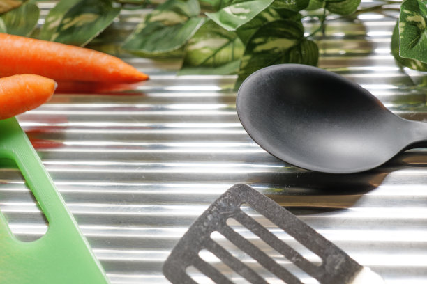 不锈钢背景上的炊具和蔬菜图片下载