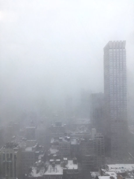 从办公室窗口望向雾蒙蒙的纽约市。低能见度，纽约天际线被雾和雨笼罩在暴风雨中。在雾中从办公室窗户看到的曼哈顿。图片下载