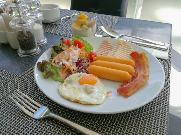 早餐有煎蛋、蔬菜沙拉和香肠图片下载