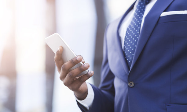 商人在智能手机上使用商业应用程序在城市地区，裁剪图片下载