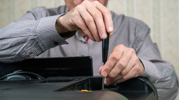 老人皱着双手拧开电视罩，用千斤顶在家里修理电视机图片下载