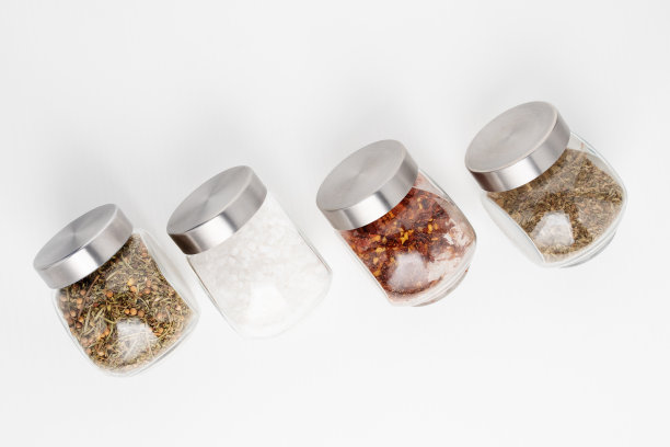 在白色背景的罐子里调味。海盐，混合香草，辣椒在白色背景上图片下载