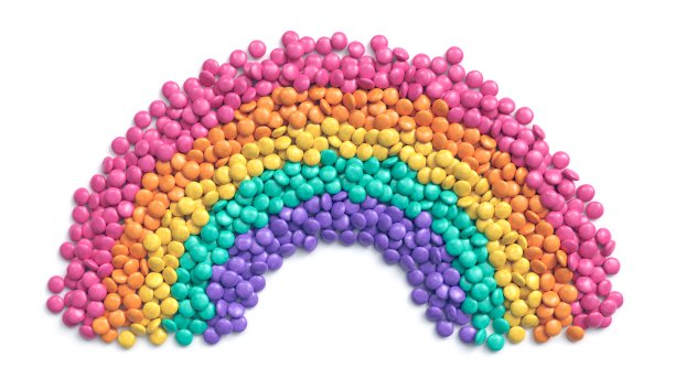 五颜六色的巧克力糖果排列成彩虹在白色的背景图片下载